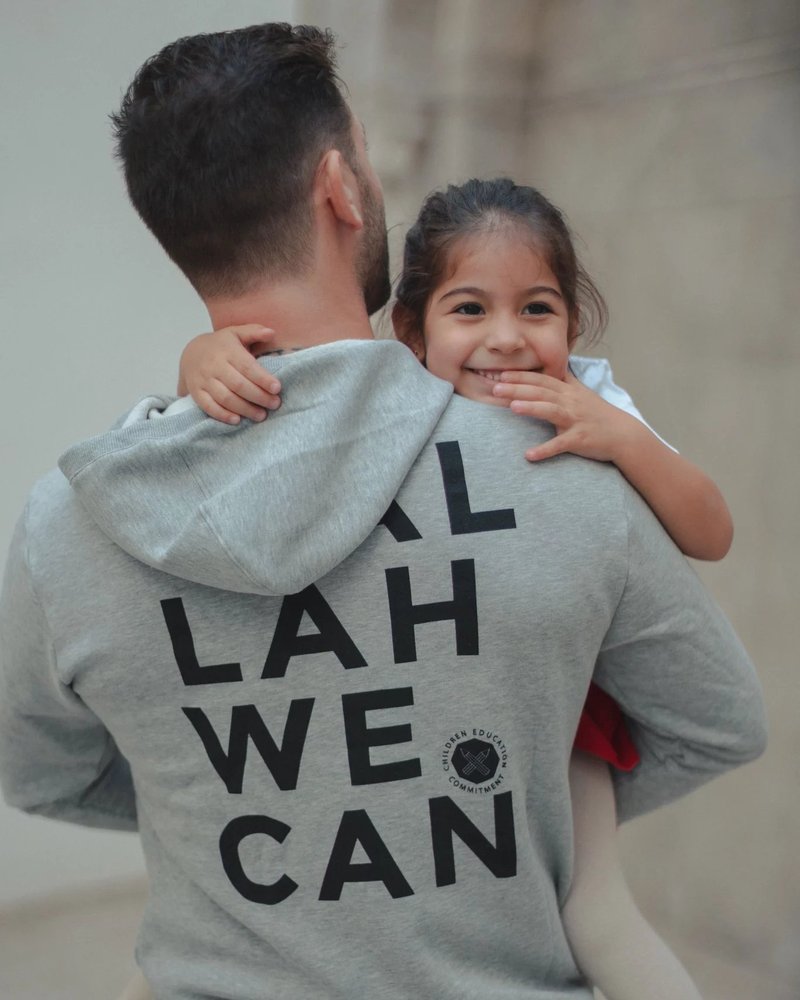 Wallah We Can — un parent et sa fille, le sweat de l'ONG bien visible